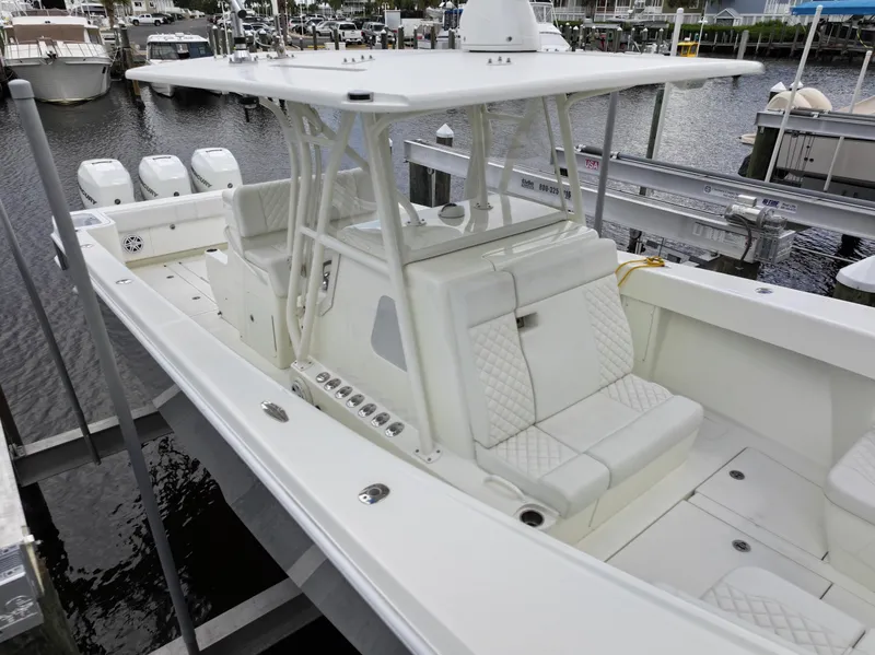 Slide: The Image of 2017 SeaVee 370z boat with white seating, docked in a marina. - 14