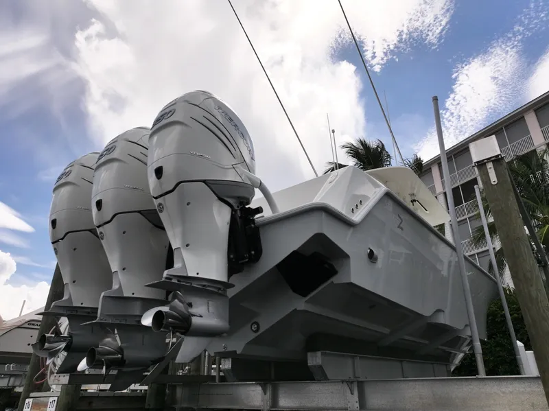 Slide: The Image of 2017 SeaVee 370z boat with triple outboard engines, docked under a cloudy sky. - 38