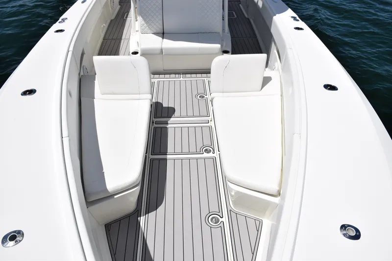 Slide: The Image of 2017 SeaVee 390Z boat interior with white seating and gray deck flooring. - 15