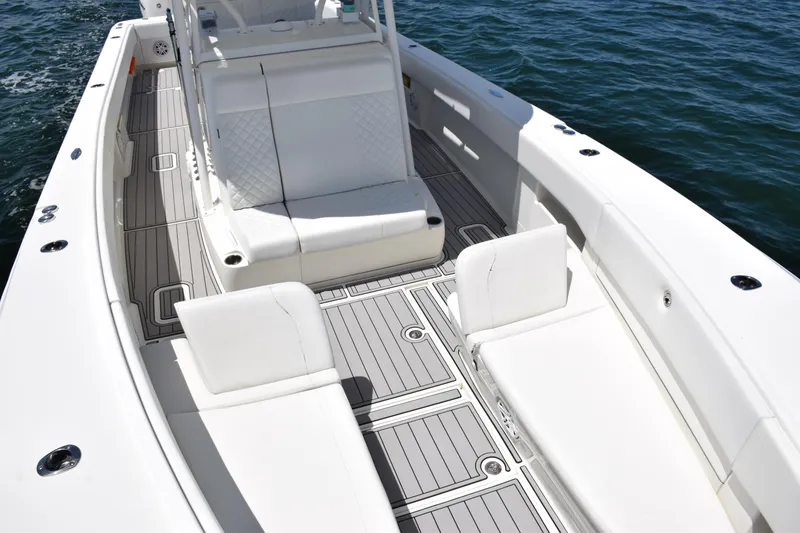 Slide: The Image of 2017 SeaVee 390Z boat interior with white seating and gray deck, on calm water. - 17