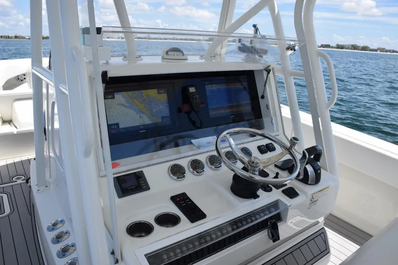 Slide: The Image of 2017 SeaVee 390Z boat console with navigation screens and steering wheel on open water. - 23