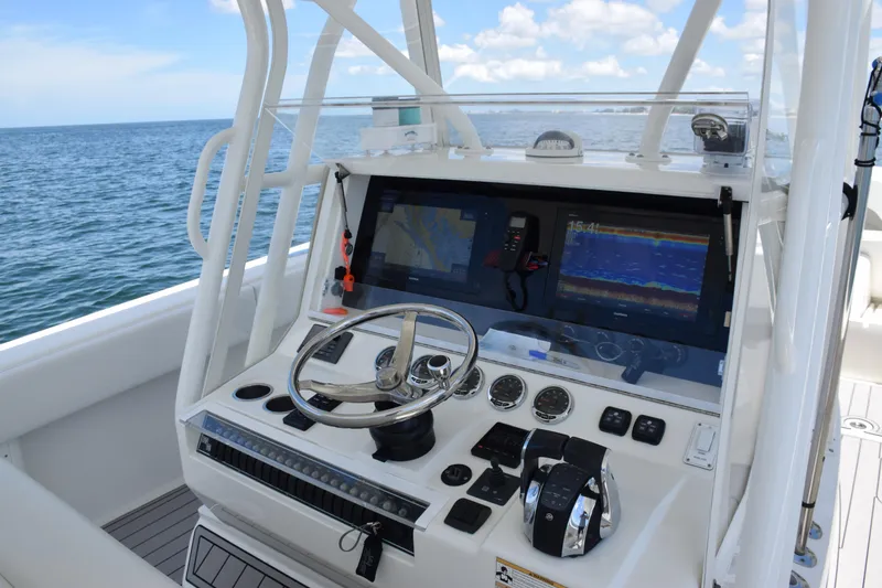 Slide: The Image of 2017 SeaVee 390Z boat console with steering wheel and navigation screens on open water. - 25