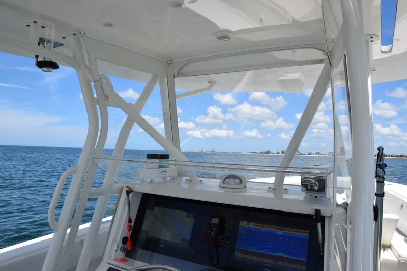 Slide: The Image of 2017 SeaVee 390Z boat dashboard with navigation equipment, overlooking calm ocean waters. - 26