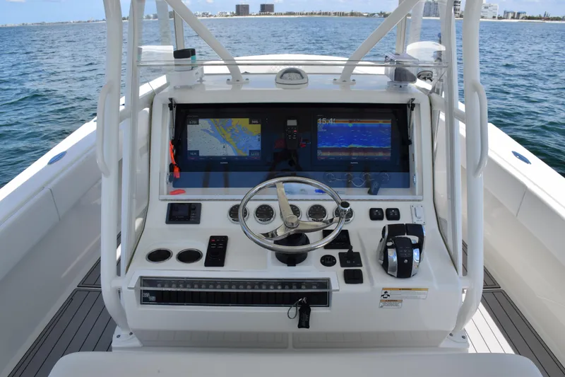 Slide: The Image of 2017 SeaVee 390Z boat helm with navigation screens and steering wheel on open water. - 28