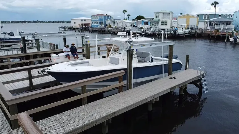 Slide: The Image of 2007 Edgewater 318CC boat docked in a marina with waterfront homes. - 1