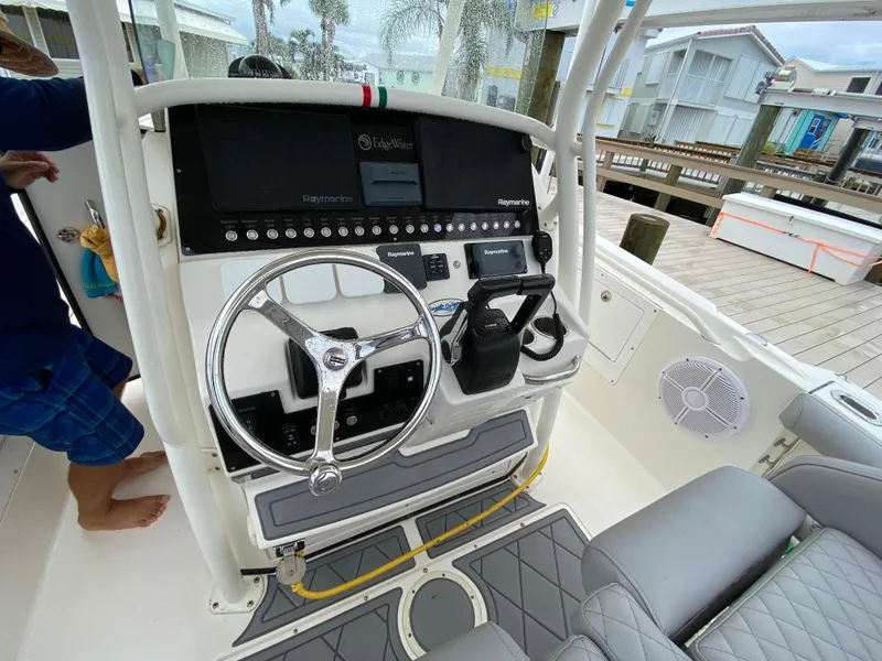Slide: The Image of 2007 Edgewater 318CC boat dashboard with steering wheel and controls. - 11