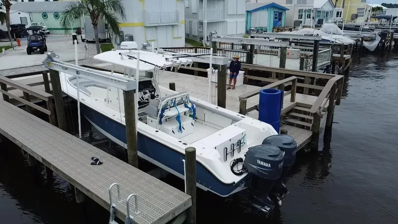 Slide: The Image of 2007 Edgewater 318CC boat docked at marina with twin Yamaha engines. - 13