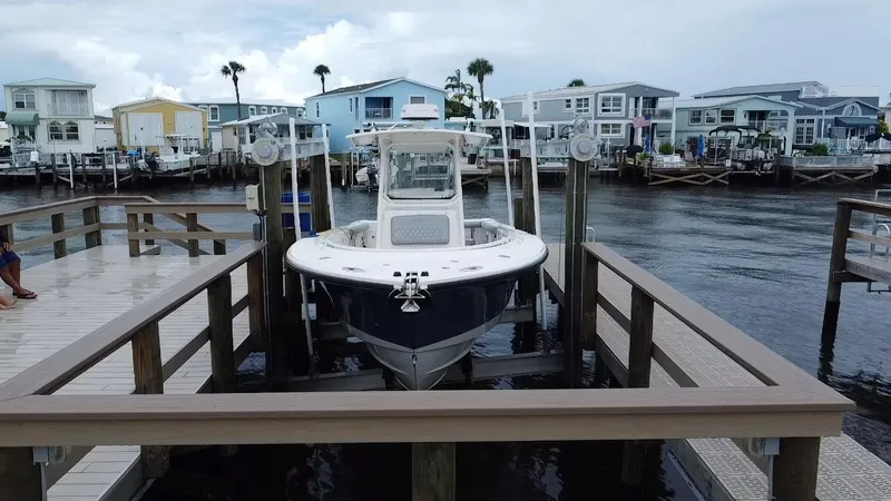 Slide: The Image of 2007 Edgewater 318CC boat docked at a marina with waterfront homes. - 2