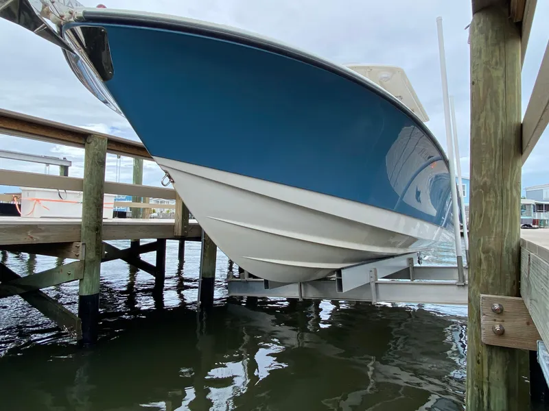 Slide: The Image of Edgewater 318CC 2007 boat on lift, blue hull, docked at marina. - 20