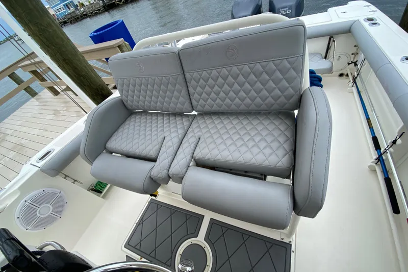 Slide: The Image of 2007 Edgewater 318CC boat with luxurious quilted gray seating at the dock. - 23