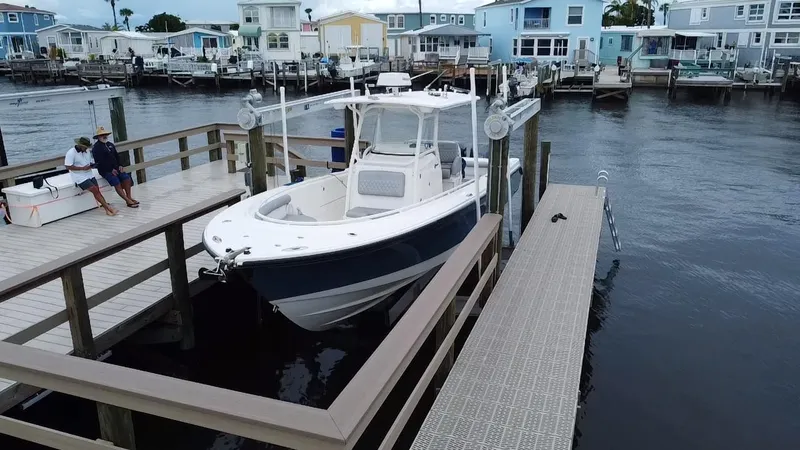 Slide: The Image of 2007 Edgewater 318CC boat docked at a marina with waterfront homes in the background. - 3