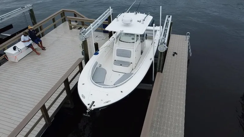 Slide: The Image of 2007 Edgewater 318CC boat docked at a marina with a person sitting nearby. - 6