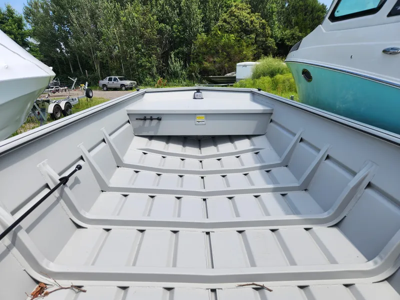 Slide: The Image of 2024 SeaArk 2072 MV boat interior, spacious and sturdy design, surrounded by greenery and other boats. - 6