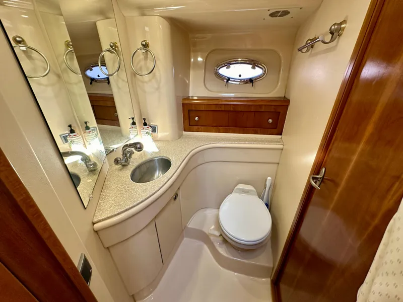 Slide: The Image of Luxurious bathroom in 2003 Meridian 411 Sedan yacht with sink, toilet, and porthole window. - 22