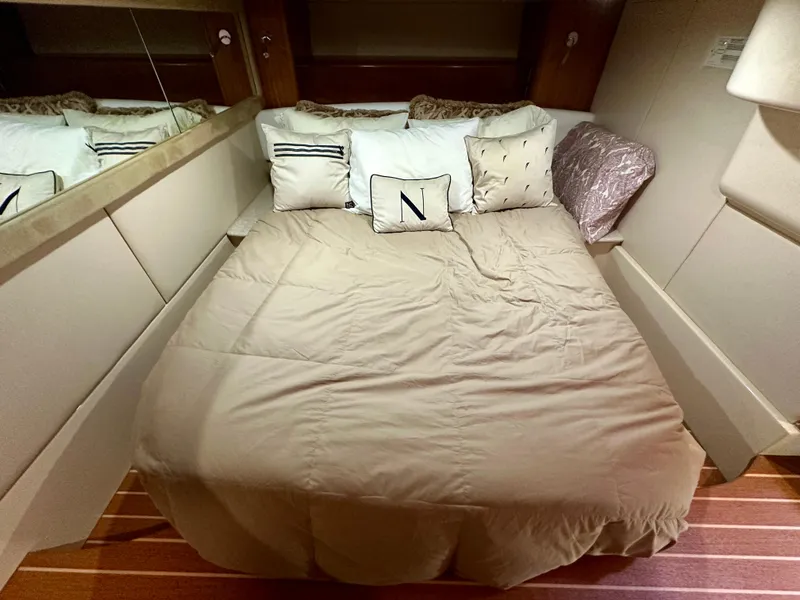 Slide: The Image of Cozy bedroom in 2003 Meridian 411 Sedan yacht with plush pillows and beige bedding. - 24