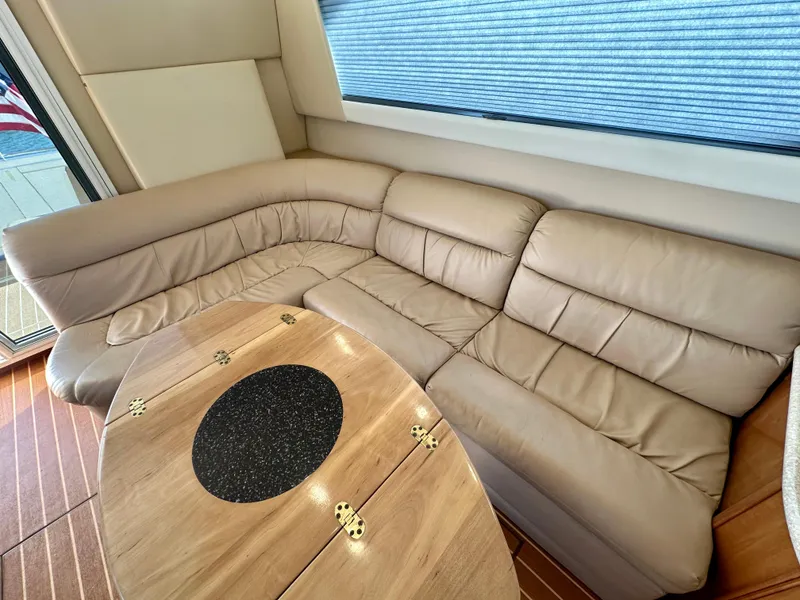Slide: The Image of Luxurious interior of 2003 Meridian 411 Sedan with beige leather seating and wooden table. - 36