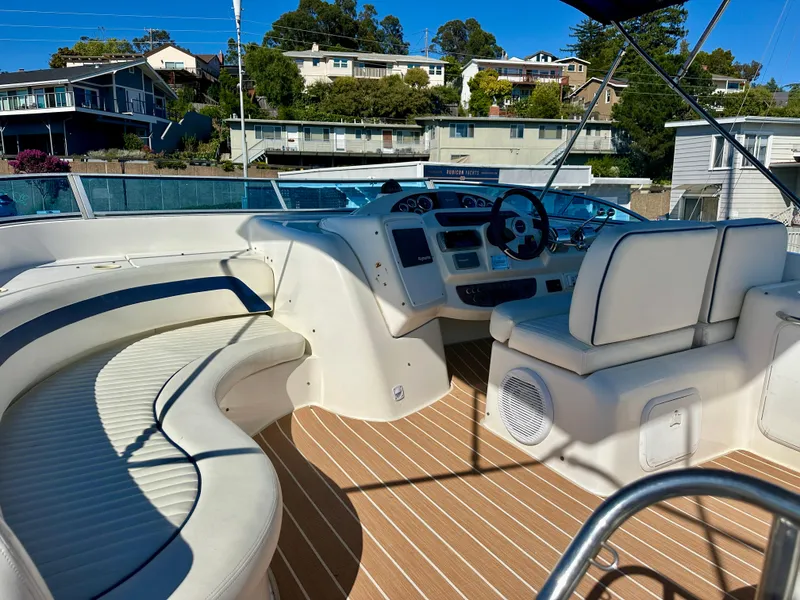Slide: The Image of 2003 Meridian 411 Sedan yacht interior with seating and helm, docked near waterfront homes. - 37