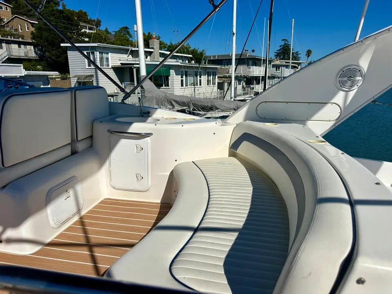 Slide: The Image of 2003 Meridian 411 Sedan yacht with white seating and wooden deck, docked near waterfront homes. - 39