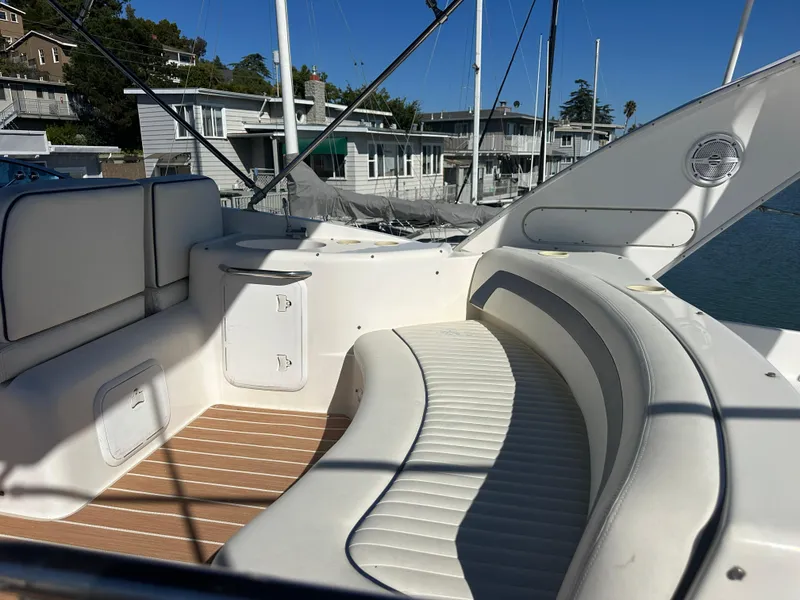 Slide: The Image of 2003 Meridian 411 Sedan yacht with white seating and wooden deck, docked near waterfront homes. - 40