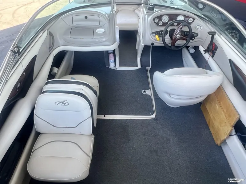 Slide: The Image of Interior of a 2004 Monterey Montura 190 LS boat with white seating and dashboard. - 4