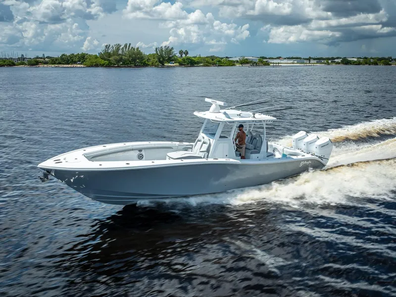 The Image of 2025 Yellowfin 36 boat cruising on a sunny day, with lush greenery in the background. - 0