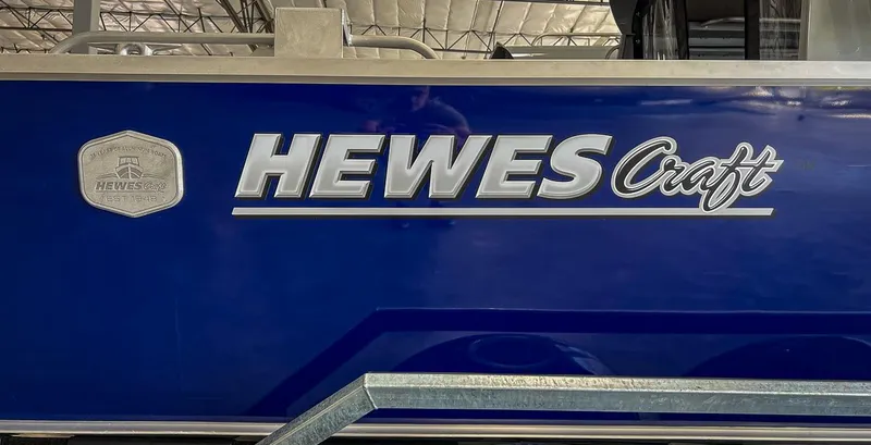 Slide: The Image of 2024 Hewescraft 210 Sea Runner ET HT boat logo on blue hull. - 23