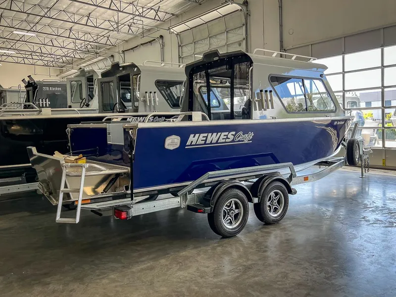 Slide: The Image of 2024 Hewescraft 210 Sea Runner ET HT boat in showroom, blue exterior, on trailer. - 3