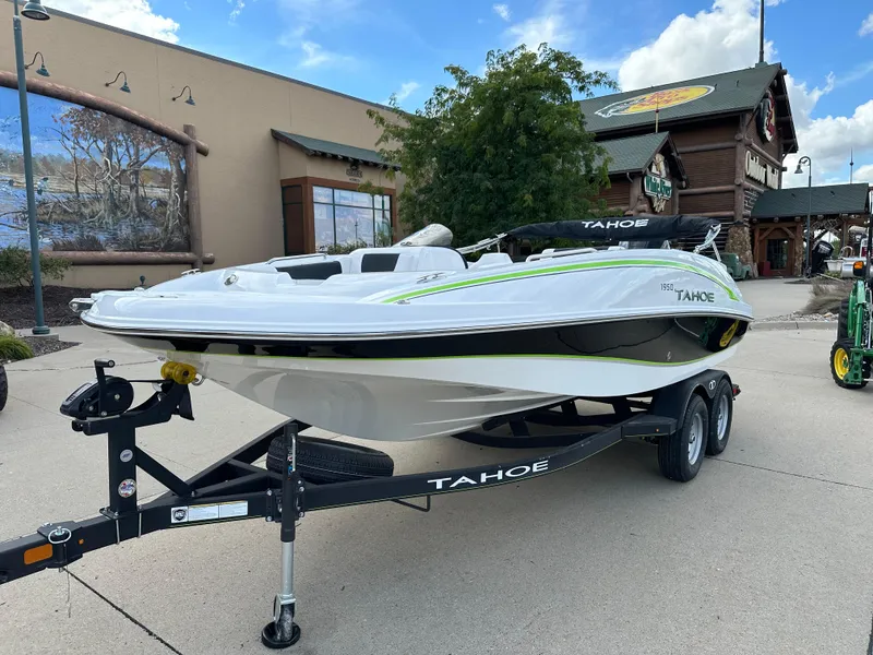 Slide: The Image of 2024 Tahoe 1950 boat on trailer, displayed outdoors near a building. - 1