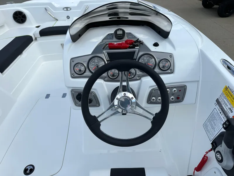 Slide: The Image of 2024 Tahoe 1950 boat dashboard with steering wheel and control panel. - 5