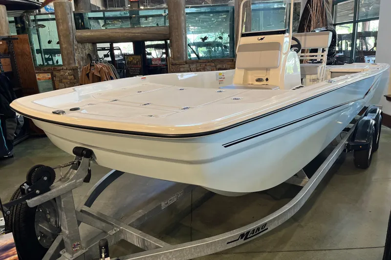 The Image of 2024 Mako Pro Skiff 19 CC boat on trailer by a serene lakeside. - 0