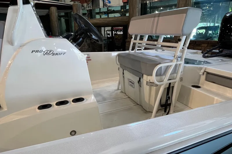 Slide: The Image of 2024 Mako Pro Skiff 19 CC boat interior with steering console and rod holders. - 7