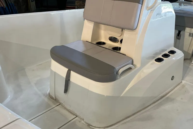 Slide: The Image of 2024 Mako Pro Skiff 19 CC boat interior with steering wheel and seating. - 9