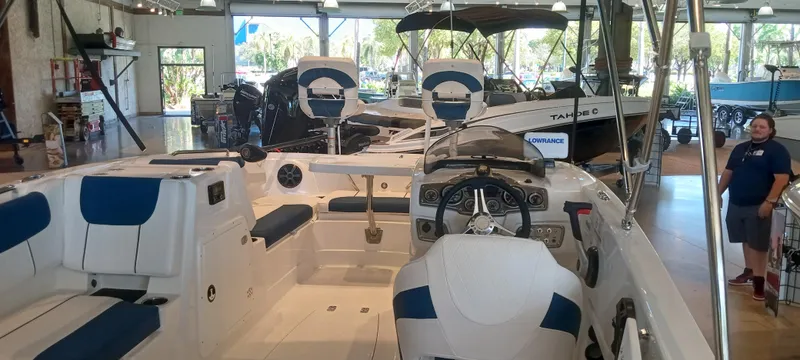 Slide: The Image of 2024 Tahoe 1950 boat interior in showroom, featuring blue and white seating. - 1