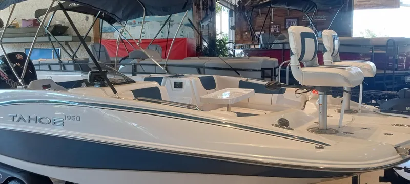 Slide: The Image of 2024 Tahoe 1950 boat in showroom, featuring sleek design and comfortable seating. - 2