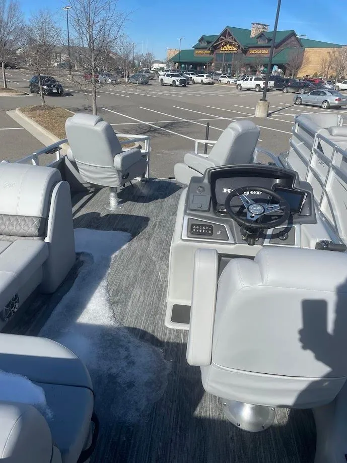 Slide: The Image of 2024 Ranger Reata 220F pontoon boat interior in a parking lot. - 3
