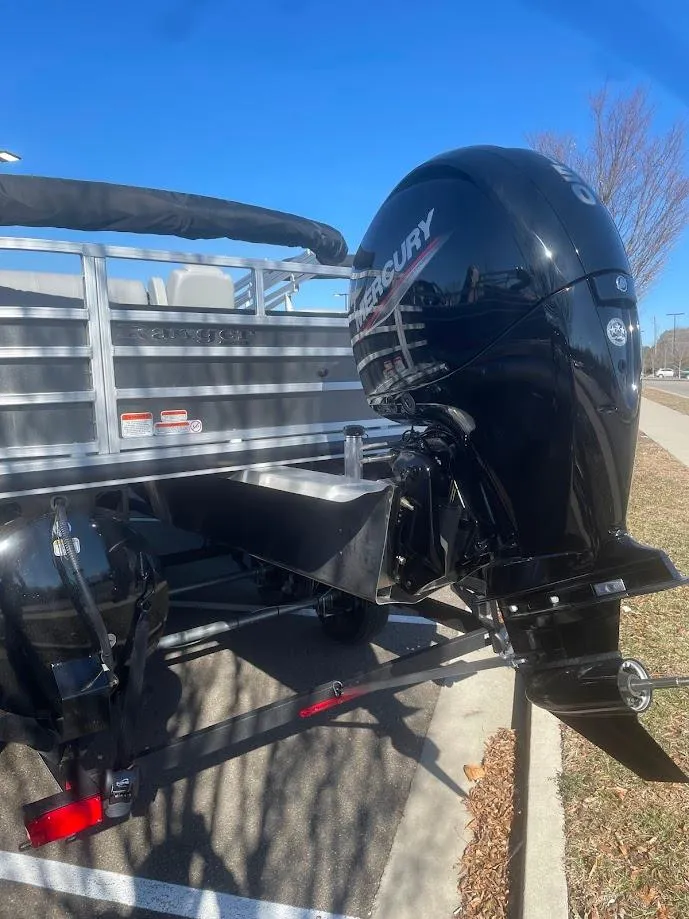 Slide: The Image of 2024 Ranger Reata 220F boat with Mercury outboard motor, parked on a sunny day. - 4