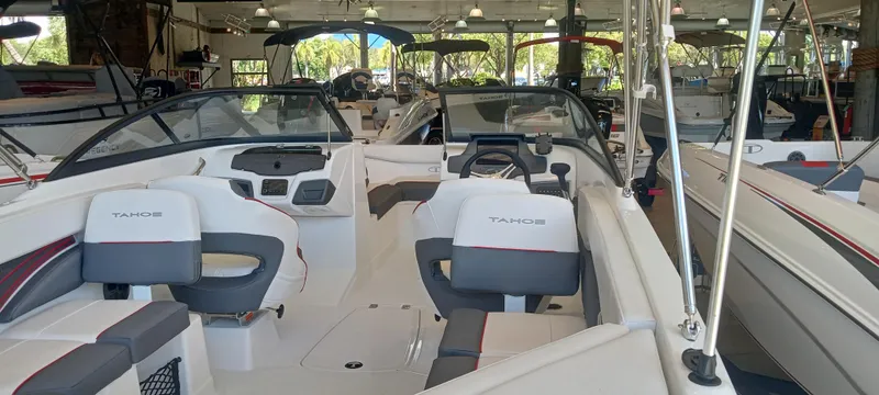 Slide: The Image of 2024 Tahoe 210 S boat interior in showroom, featuring sleek seating and modern design. - 1