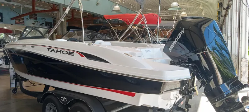 Slide: The Image of 2024 Tahoe 210 S boat with Mercury engine in showroom. - 2