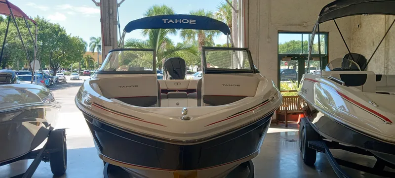 Slide: The Image of 2024 Tahoe 210 S boat displayed indoors, surrounded by other boats. - 3