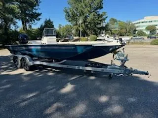 Slide: The Image of 2024 Ranger RB200 boat on trailer in parking lot, surrounded by trees. - 13