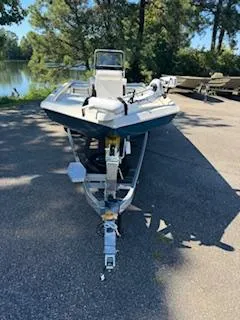 Slide: The Image of 2024 Ranger RB200 boat on trailer near a lake, surrounded by trees. - 14