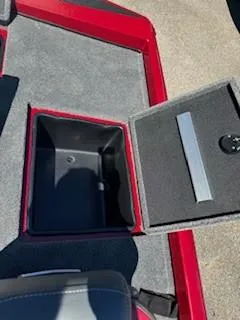 Slide: The Image of 2024 Ranger RT188P boat storage compartment with open lid, red and gray interior. - 18