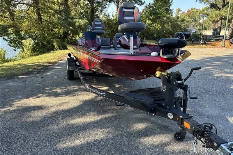 Slide: The Image of 2024 Ranger RT188P boat on trailer, parked outdoors near trees. - 3