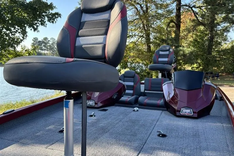 Slide: The Image of 2024 Ranger RT188P boat interior with cushioned seats, set against a scenic lakeside backdrop. - 11