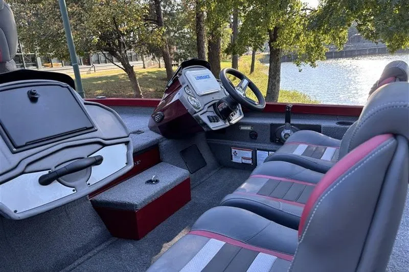 Slide: The Image of 2024 Ranger RT188P boat interior with seating and steering console by a lake. - 16