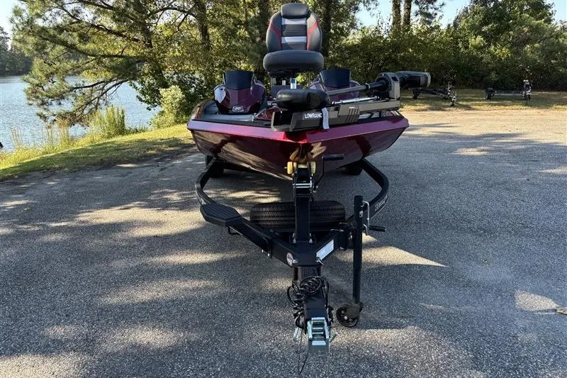 Slide: The Image of 2024 Ranger RT188P boat on trailer, parked near a scenic lake. - 2