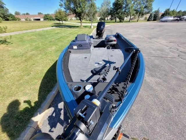 Slide: The Image of 2024 Ranger VS1682SC Angler boat parked on pavement, surrounded by greenery. - 3