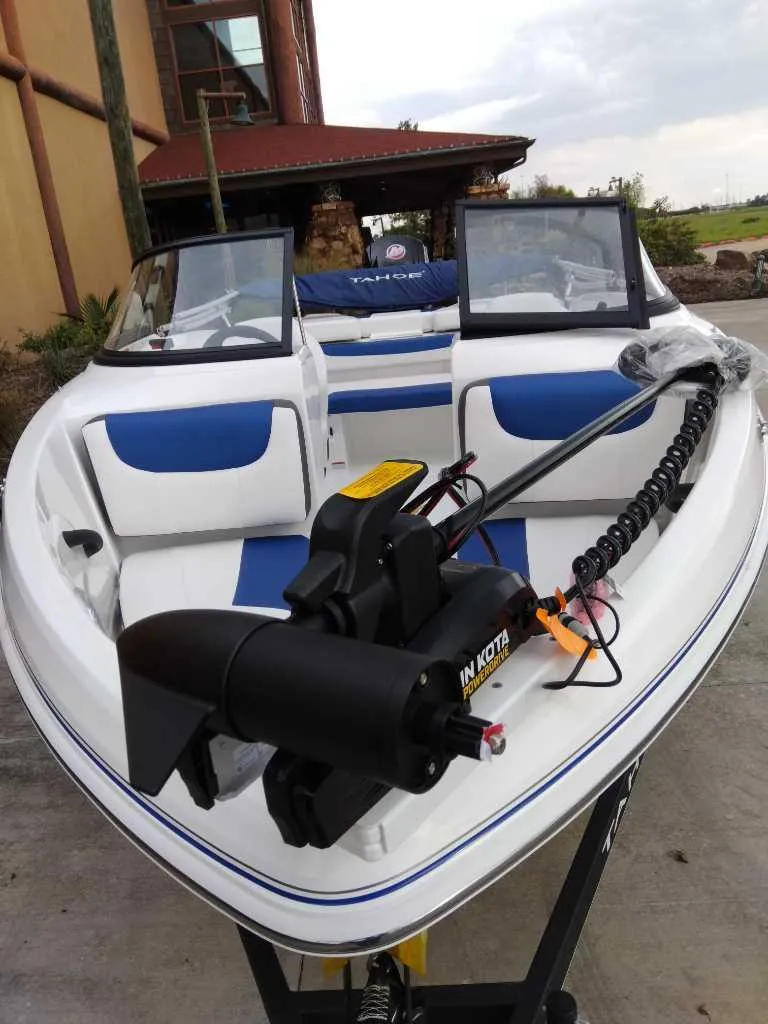 Slide: The Image of 2024 Tahoe 185 S boat with blue and white interior, featuring a mounted trolling motor. - 1