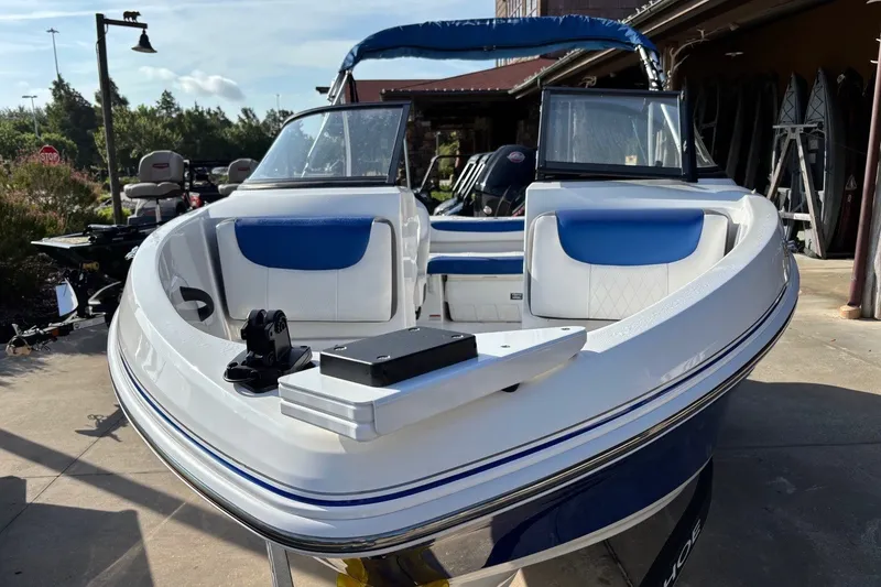 Slide: The Image of 2024 Tahoe 185 S boat with blue and white seating, parked outdoors. - 6