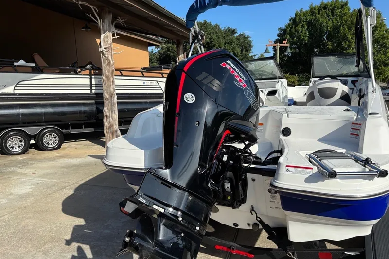 Slide: The Image of 2024 Tahoe 185 S boat with Mercury 115 Pro XS outboard motor in a sunny marina. - 11